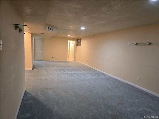 carpeted empty room with a textured ceiling