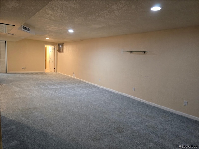 basement featuring a textured ceiling and carpet floors