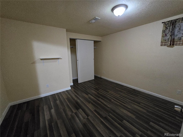 unfurnished bedroom with a closet, dark wood-type flooring, and a textured ceiling