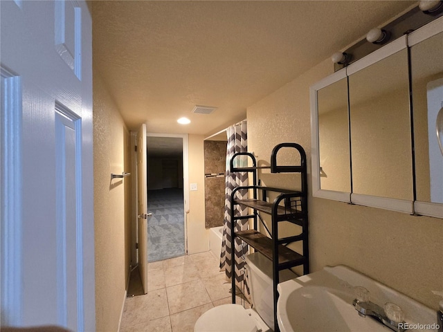 bathroom featuring a textured ceiling and tile patterned floors