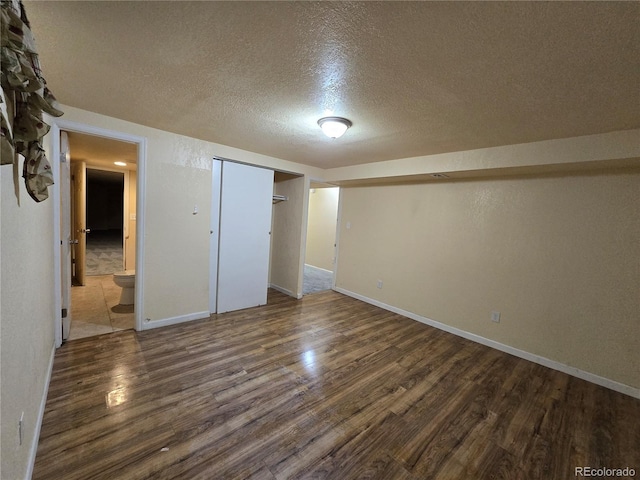 basement featuring a textured ceiling and dark wood-type flooring