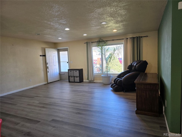 living area featuring a textured ceiling and dark hardwood / wood-style floors