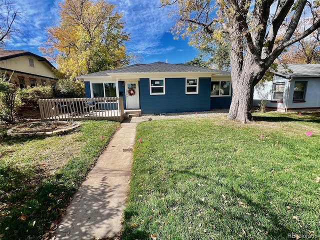 single story home featuring covered porch and a front yard