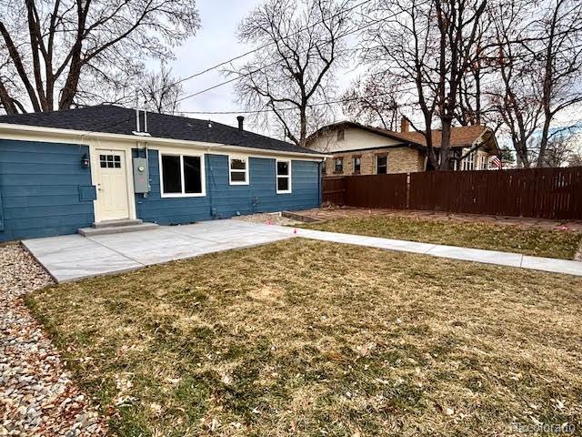 rear view of property with a patio and a lawn