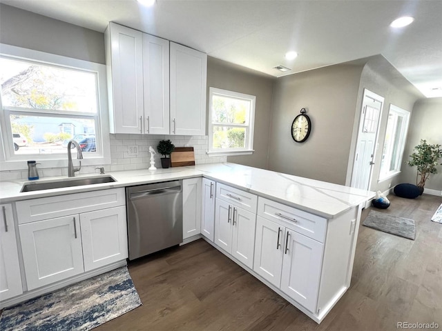 kitchen featuring dark wood-type flooring, sink, white cabinetry, stainless steel dishwasher, and kitchen peninsula