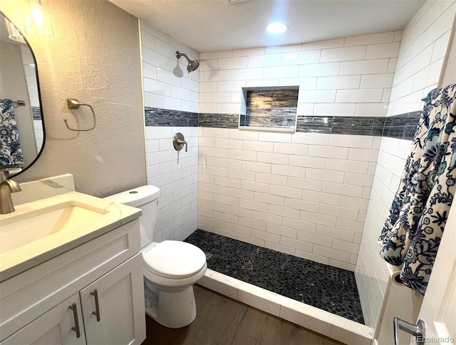 bathroom featuring hardwood / wood-style flooring, a shower with curtain, toilet, and vanity