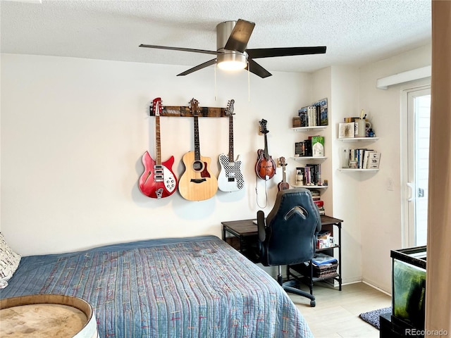 bedroom featuring ceiling fan, a textured ceiling, and light hardwood / wood-style flooring