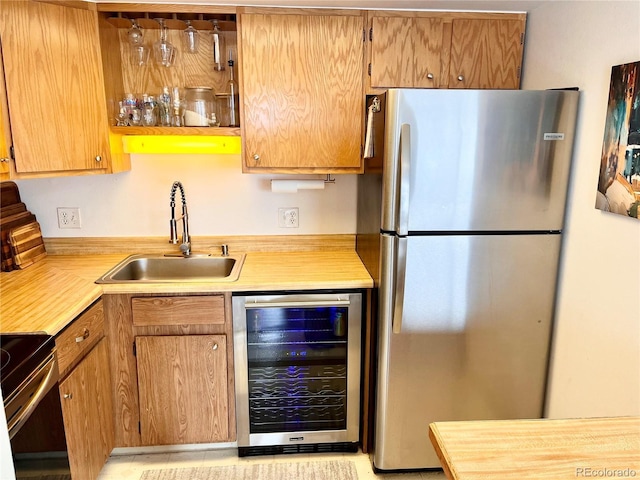 kitchen with stainless steel fridge, sink, beverage cooler, and electric stove