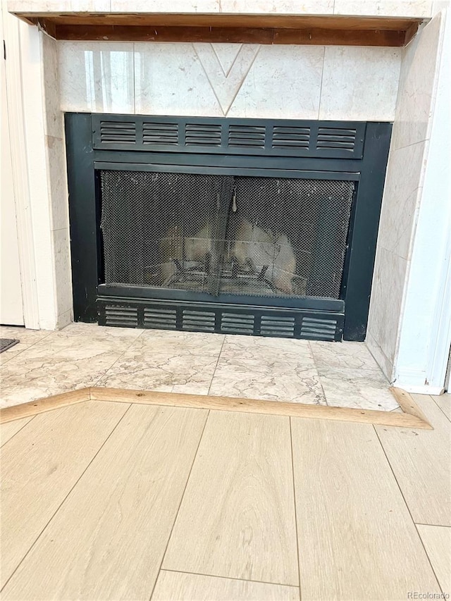 details featuring wood-type flooring and a tile fireplace