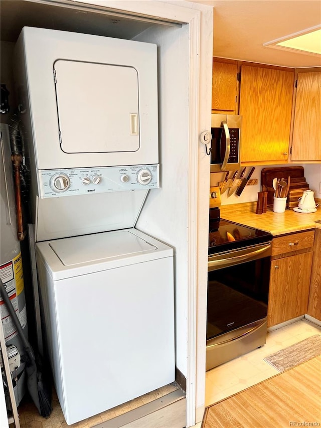 laundry room featuring stacked washer and dryer and gas water heater