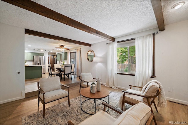 2130 Squires St, Longmont, CO 80501 - living area featuring a textured ceiling, beam ceiling, light wood-type flooring, and a ceiling fan