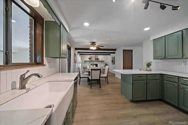 2130 Squires St, Longmont, CO 80501 - kitchen featuring green cabinets, a ceiling fan, a peninsula, backsplash, and a textured ceiling