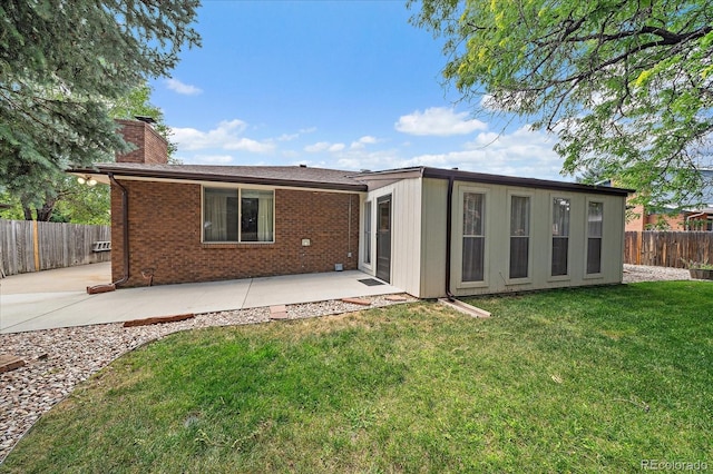 2130 Squires St, Longmont, CO 80501 - rear view of house with a patio, a chimney, brick siding, and a fenced backyard