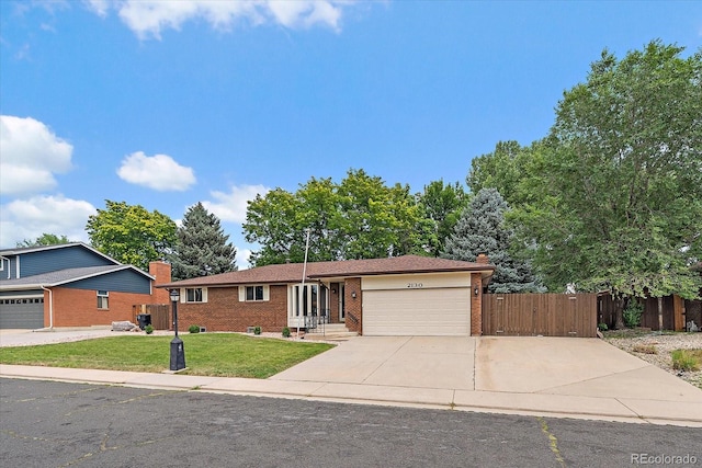 2130 Squires St, Longmont, CO 80501 - ranch-style house featuring brick siding, a garage, driveway, and a chimney