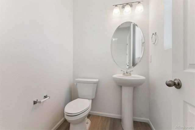 bathroom with hardwood / wood-style floors, toilet, and sink