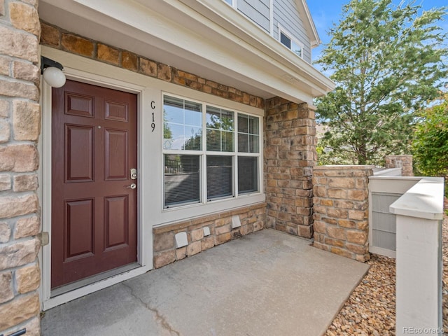 23500 E Alamo Pl Unit C, Aurora, CO 80016 - view of exterior entry with a porch and stone siding
