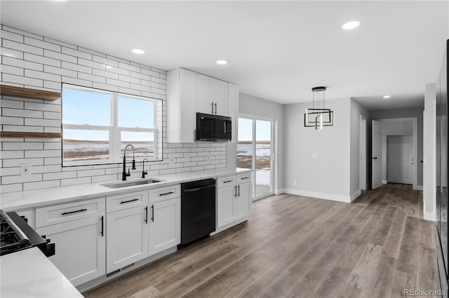 kitchen featuring white cabinetry, black dishwasher, and sink