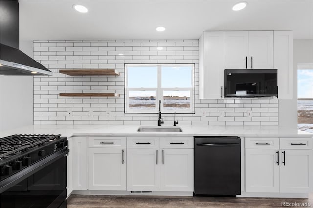 kitchen featuring black appliances, sink, white cabinets, and wall chimney exhaust hood