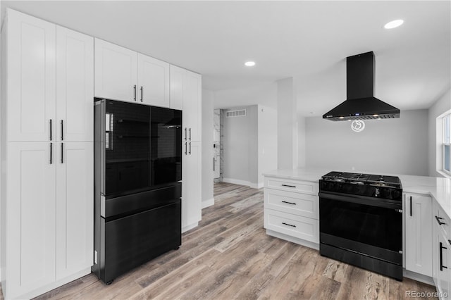 kitchen with white cabinetry, light wood-type flooring, extractor fan, and black appliances