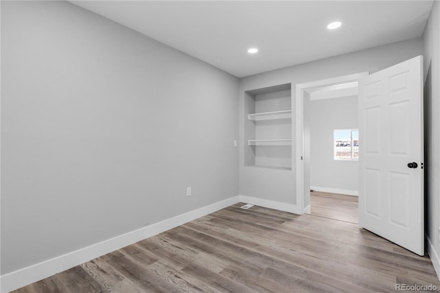 unfurnished bedroom featuring wood-type flooring and a closet