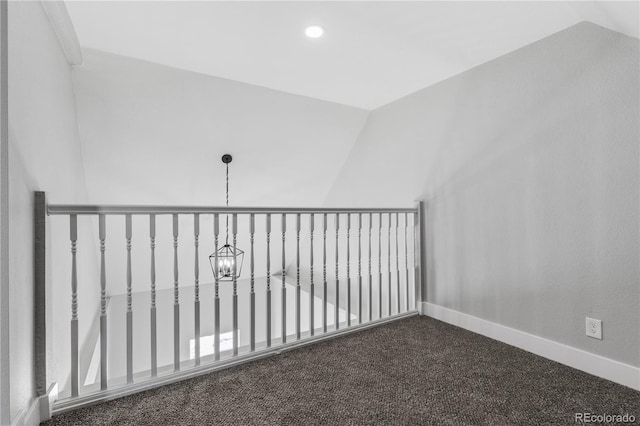 carpeted empty room with lofted ceiling and a chandelier