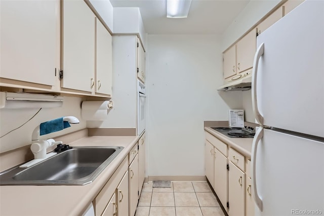 kitchen with white cabinets, light tile patterned floors, white refrigerator, gas stovetop, and sink