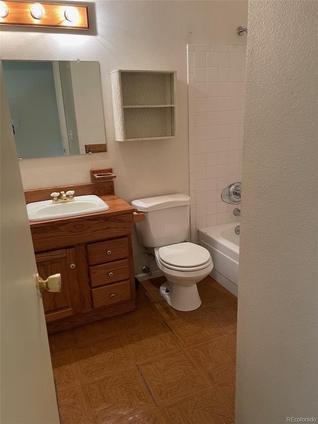 full bathroom with tiled shower / bath, vanity, and toilet