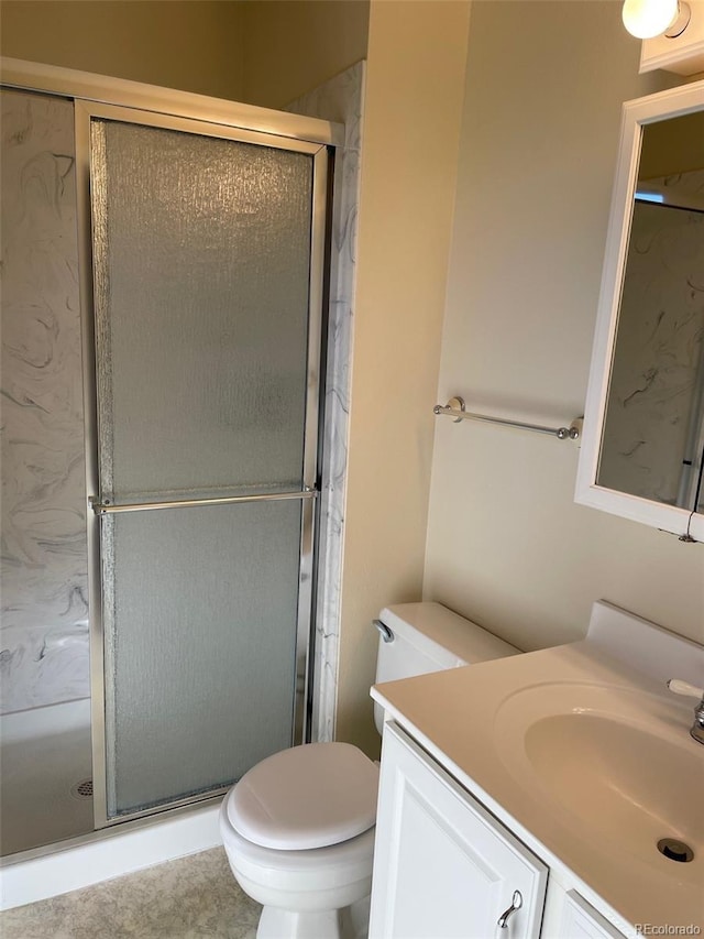 bathroom featuring vanity, toilet, and a shower with shower door