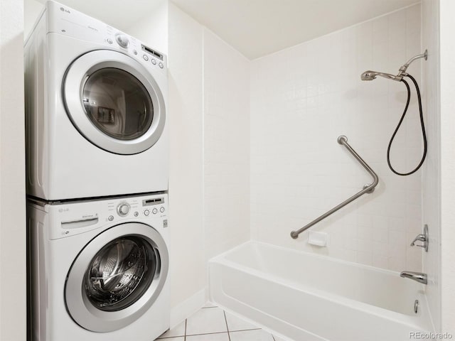 clothes washing area with light tile patterned floors and stacked washer and clothes dryer