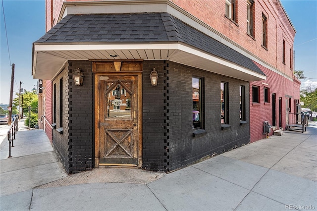 doorway to property with brick siding