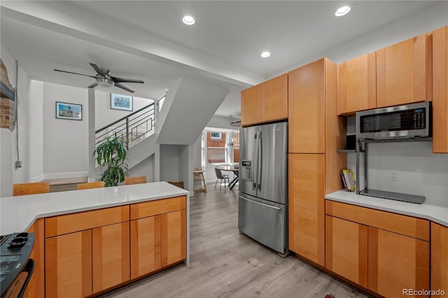 kitchen featuring appliances with stainless steel finishes, light wood finished floors, light countertops, ceiling fan, and recessed lighting