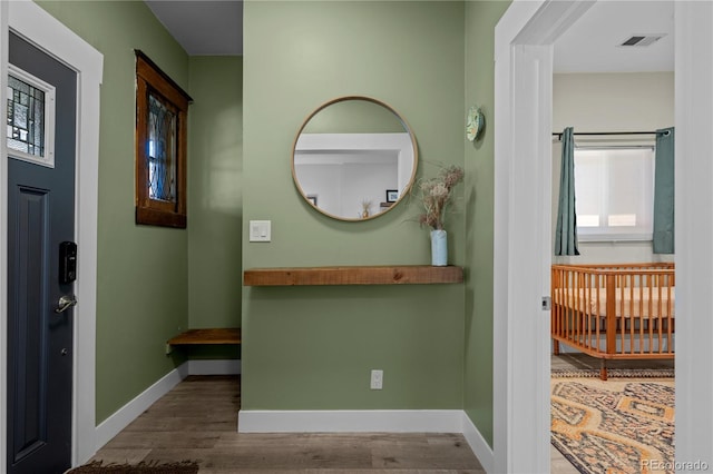 corridor with wood finished floors and baseboards