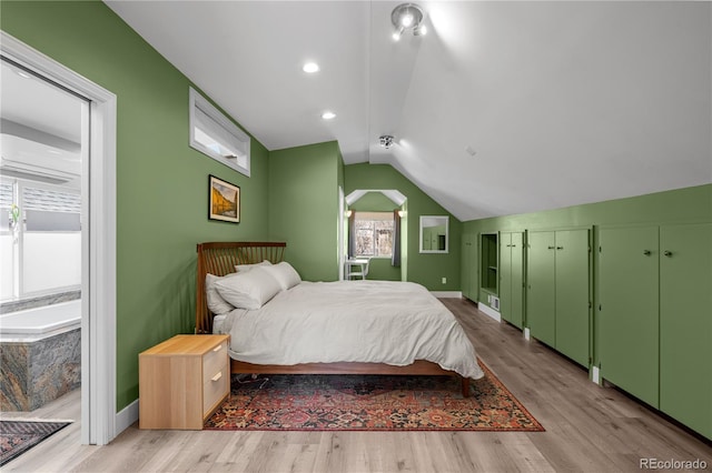 bedroom featuring light wood-style floors, vaulted ceiling, and baseboards