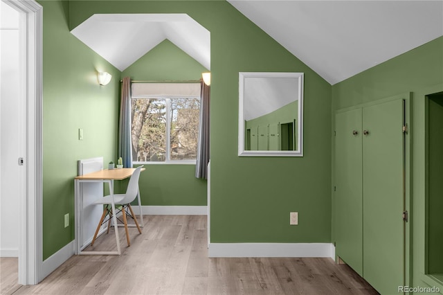 home office with vaulted ceiling, light wood-style floors, and baseboards