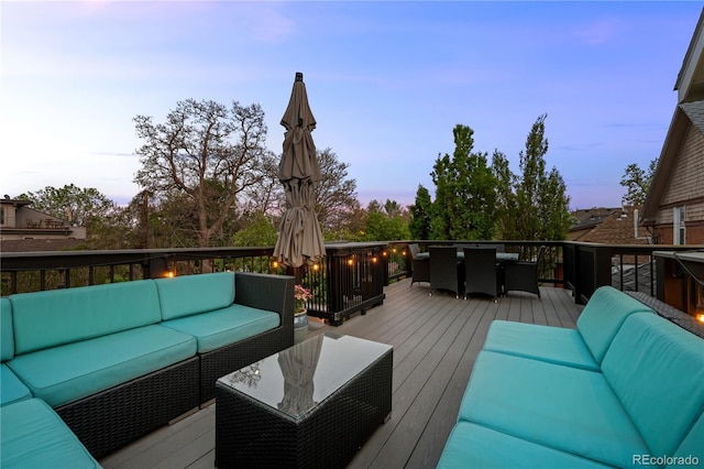 deck at dusk featuring an outdoor living space and outdoor dining area