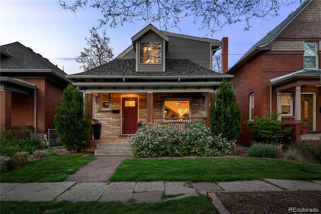 view of front of home with covered porch and a front yard