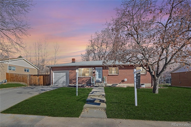 ranch-style house featuring a yard and a garage