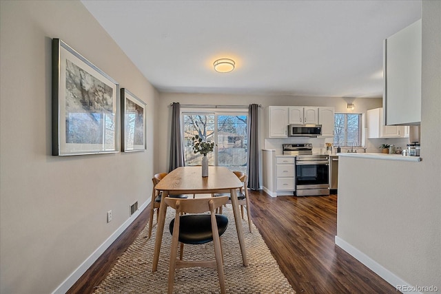 dining space with dark wood-type flooring and sink