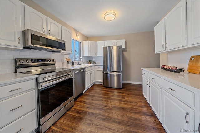 kitchen with sink, decorative backsplash, dark hardwood / wood-style flooring, white cabinetry, and stainless steel appliances