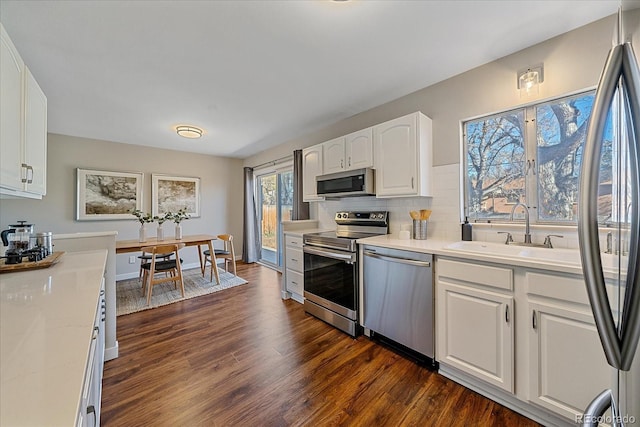 kitchen with white cabinets, plenty of natural light, and appliances with stainless steel finishes