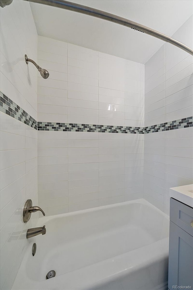 bathroom with vanity and tiled shower / bath