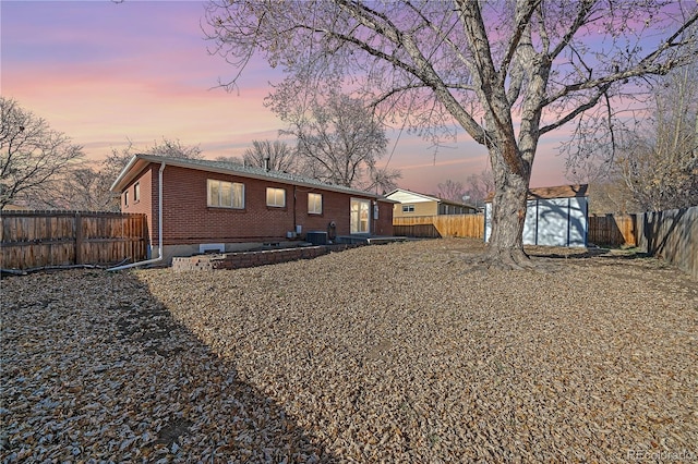 back house at dusk with a storage unit