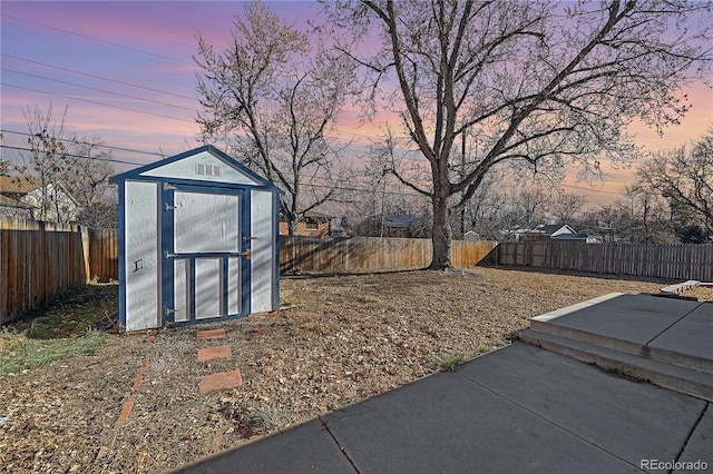 yard at dusk featuring a patio and a storage unit