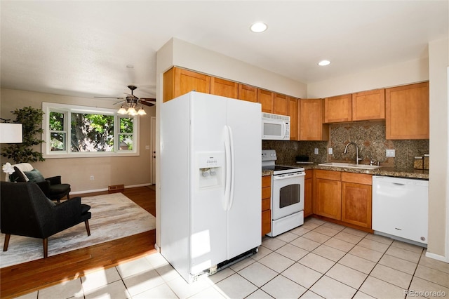 7695 S Harlan St, Littleton, CO 80128 - kitchen featuring white appliances, a sink, open floor plan, light tile patterned floors, and backsplash