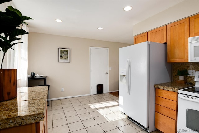 7695 S Harlan St, Littleton, CO 80128 - kitchen with white appliances, brown cabinets, recessed lighting, tasteful backsplash, and light tile patterned floors