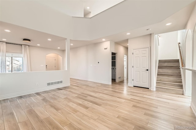 unfurnished living room featuring light wood-style floors, recessed lighting, visible vents, and stairway