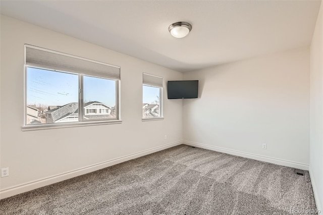 unfurnished room with carpet floors and baseboards