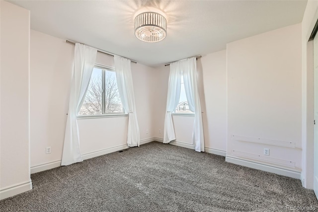 carpeted empty room featuring baseboards