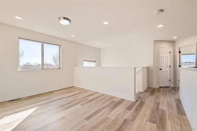 spare room featuring light wood finished floors, visible vents, baseboards, and recessed lighting