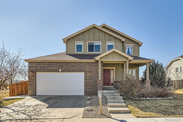 view of front of home with an attached garage, brick siding, fence, concrete driveway, and board and batten siding